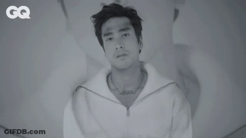 A Black And White Photo Of A Man With A Tattoo On His Chest GIF