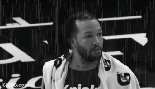 A Black And White Photo Of A Man With A Towel Wrapped Around His Neck . GIF