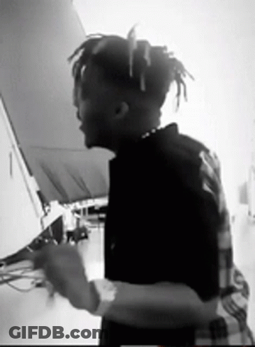 A Black And White Photo Of A Man With Dreadlocks GIF