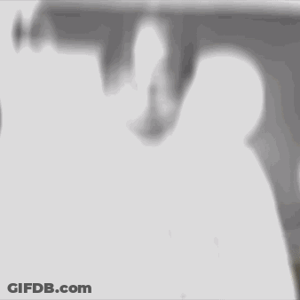 A Black And White Photo Of A Man With Dreadlocks Wearing A White Shirt Giving The Middle Finger . GIF