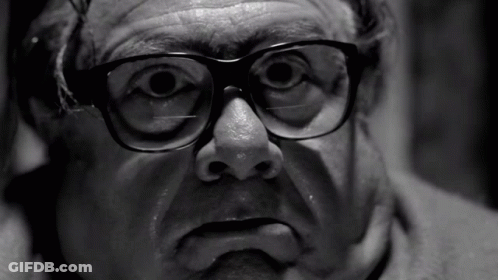 A Black And White Photo Of A Man With Glasses On GIF