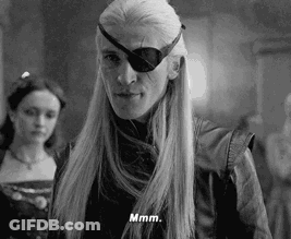 A Black And White Photo Of A Man With Long Hair And A Eye Patch On His Face . GIF