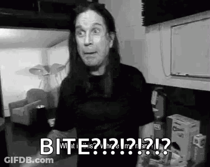 A Black And White Photo Of A Man With Long Hair Making A Funny Face While Standing In A Living Room . GIF