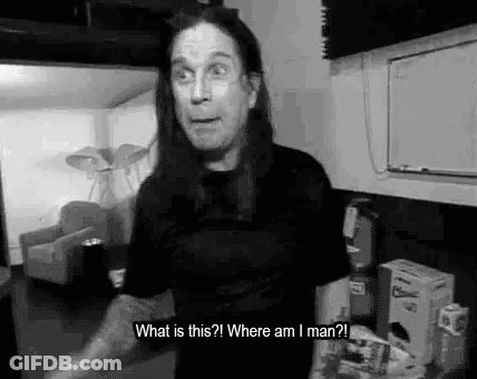 A Black And White Photo Of A Man With Long Hair Standing In A Room And Talking . GIF