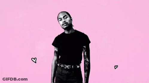 A Black And White Photo Of A Man With Tattoos On His Arms Standing On A Pink Background . GIF