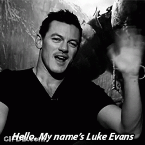 A Black And White Photo Of A Man With The Words Hello My Name 'S Luke Evans Below Him GIF