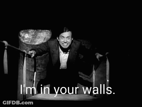 A Black And White Photo Of A Man With The Words I 'M In Your Walls Behind Him GIF