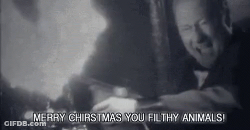 A Black And White Photo Of A Man With The Words `` Merry Christmas You Filthy Animals '' Written On The Bottom . GIF