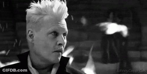 A Black And White Photo Of A Man With White Hair In A Suit . GIF