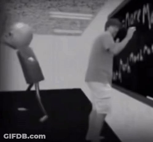 A Black And White Photo Of A Man Writing On A Chalkboard GIF
