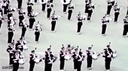 A Black And White Photo Of A Marching Band Playing Drums GIF