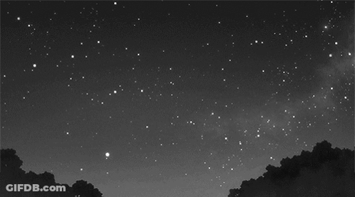 A Black And White Photo Of A Night Sky With A Shooting Star GIF