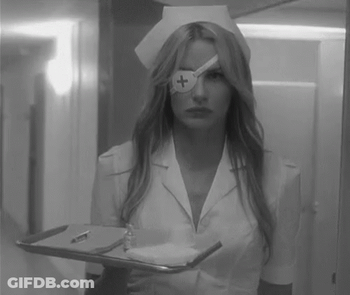 A Black And White Photo Of A Nurse Holding A Tray With A Cross On Her Eye . GIF