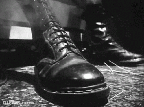 A Black And White Photo Of A Pair Of Boots GIF