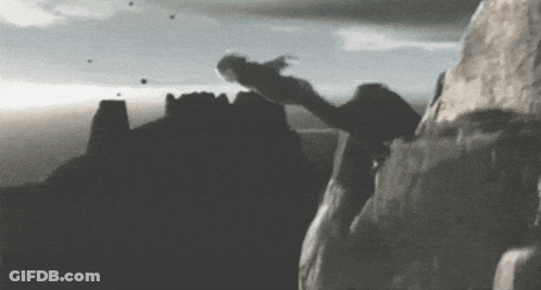 A Black And White Photo Of A Person Climbing Up A Mountain GIF