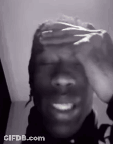 A Black And White Photo Of A Person Covering Their Face With Their Hands . GIF