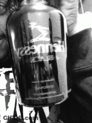A Black And White Photo Of A Person Holding A Bottle Of Hennessy GIF