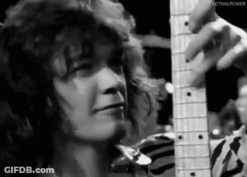 A Black And White Photo Of A Person Holding A Guitar . GIF
