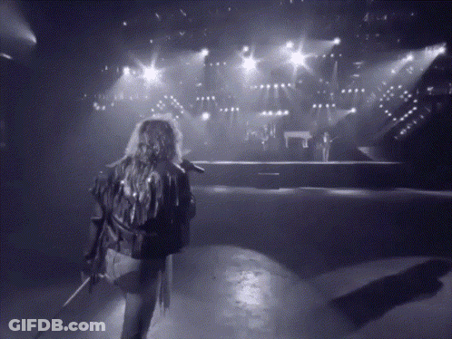 A Black And White Photo Of A Person Holding A Microphone GIF