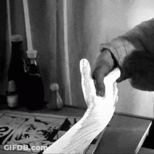 A Black And White Photo Of A Person Holding A Piece Of Paper GIF