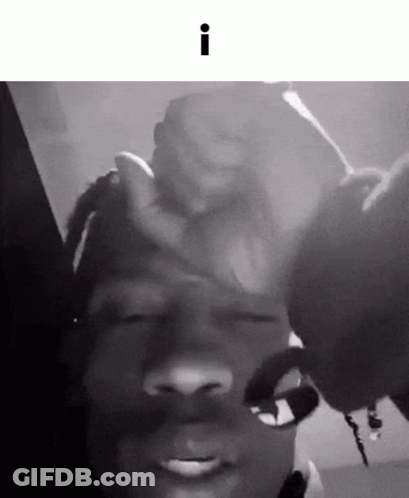 A Black And White Photo Of A Person Holding Another Person 'S Hand On Their Forehead . GIF