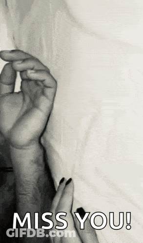 A Black And White Photo Of A Person Holding Another Person 'S Hand With The Words `` Miss You '' Written On It . GIF