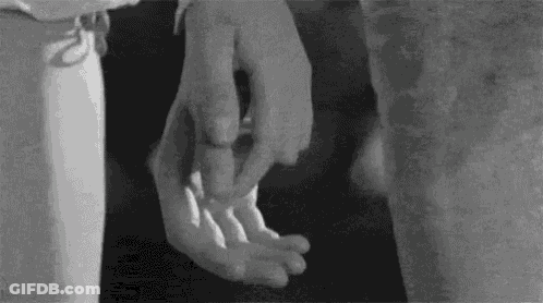 A Black And White Photo Of A Person Holding Another Person 'S Hands . GIF