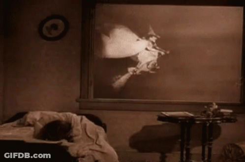 A Black And White Photo Of A Person Laying On A Bed In A Room . GIF