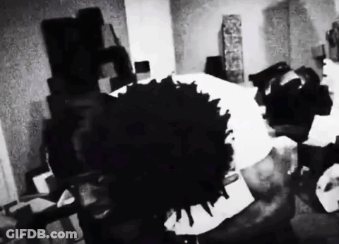 A Black And White Photo Of A Person Laying On A Bed With A Large Black Spot On The Floor . GIF
