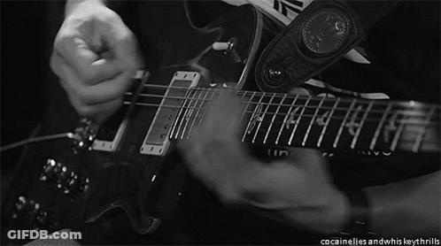 A Black And White Photo Of A Person Playing A Guitar With A Strap That Says Inventive GIF