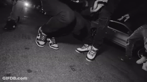 A Black And White Photo Of A Person 'S Feet Wearing Nike Shoes GIF