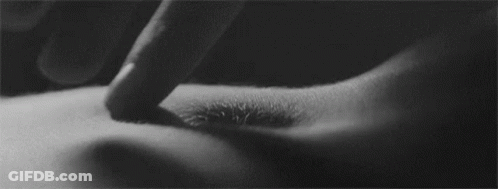 A Black And White Photo Of A Person 'S Finger Touching A Hole In Their Stomach . GIF