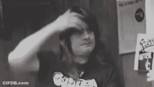 A Black And White Photo Of A Person Scratching Their Head With Their Hand . GIF