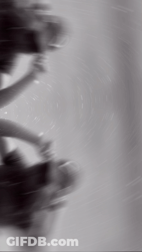 A Black And White Photo Of A Person Spinning A Steering Wheel GIF