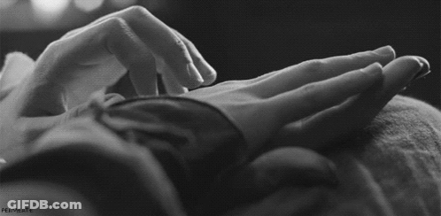 A Black And White Photo Of A Person Touching Another Person 'S Hand . GIF