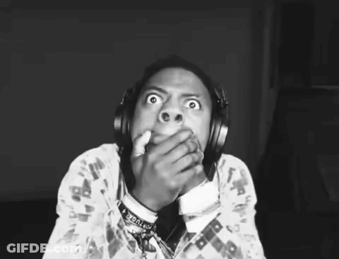 A Black And White Photo Of A Person Wearing Headphones And Covering Their Mouth . GIF