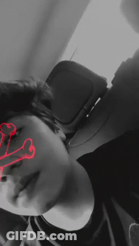 A Black And White Photo Of A Person With A Red Skull In The Background GIF