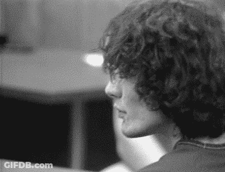 A Black And White Photo Of A Person With Curly Hair . GIF