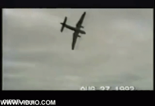 A Black And White Photo Of A Plane Flying Through The Air . GIF