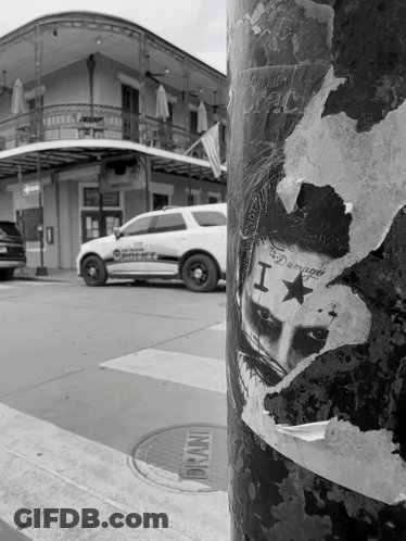 A Black And White Photo Of A Police Car With A Sticker On It That Says I Am Damaged GIF