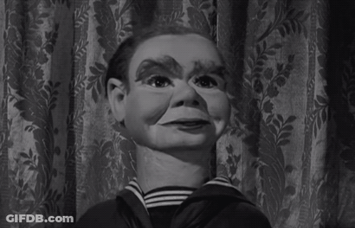 A Black And White Photo Of A Puppet With A Striped Shirt GIF