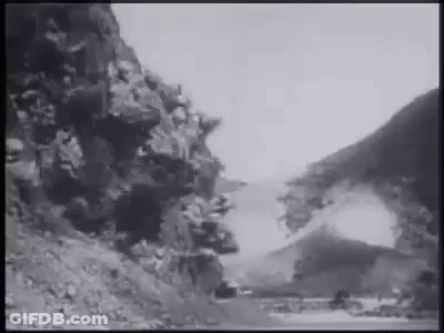 A Black And White Photo Of A Road Going Through A Mountain Valley . GIF