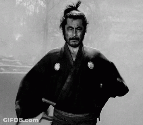 A Black And White Photo Of A Samurai Holding A Sword In His Hand . GIF