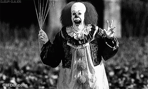 A Black And White Photo Of A Scary Clown Holding A Bunch Of Balloons . GIF