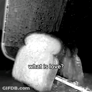 A Black And White Photo Of A Slice Of Bread Being Toasted With The Words `` What Is Love '' Written On It . GIF