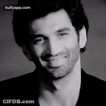 A Black And White Photo Of A Smiling Man . GIF