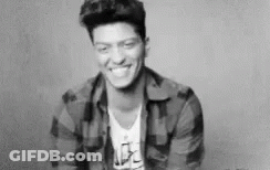 A Black And White Photo Of A Smiling Man In A Plaid Shirt . GIF