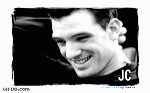 A Black And White Photo Of A Smiling Man With The Name Jc GIF