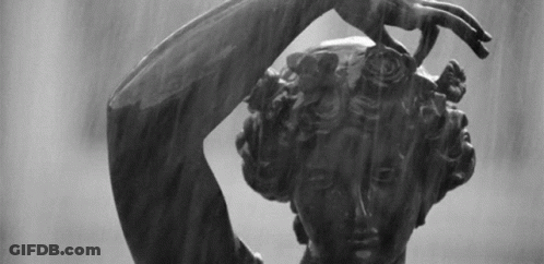 A Black And White Photo Of A Statue Of A Woman With Her Hand On Her Head GIF