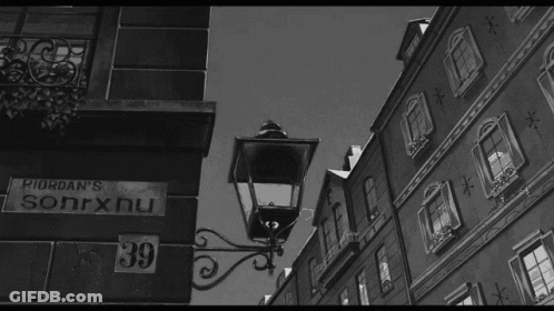 A Black And White Photo Of A Street With A Sign That Says Riordan 'S Sonrxnu GIF